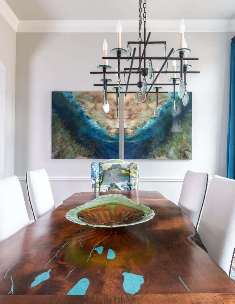 A nature-inspired dining room with live edge table, modern chandelier, mineral art