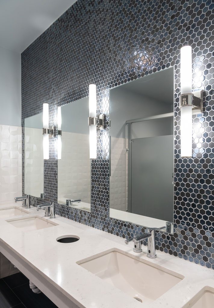 Blue glass backsplash and mid-century modern wall sconces, office bathroom interior design by Nicole Arnold Interiors, Dallas